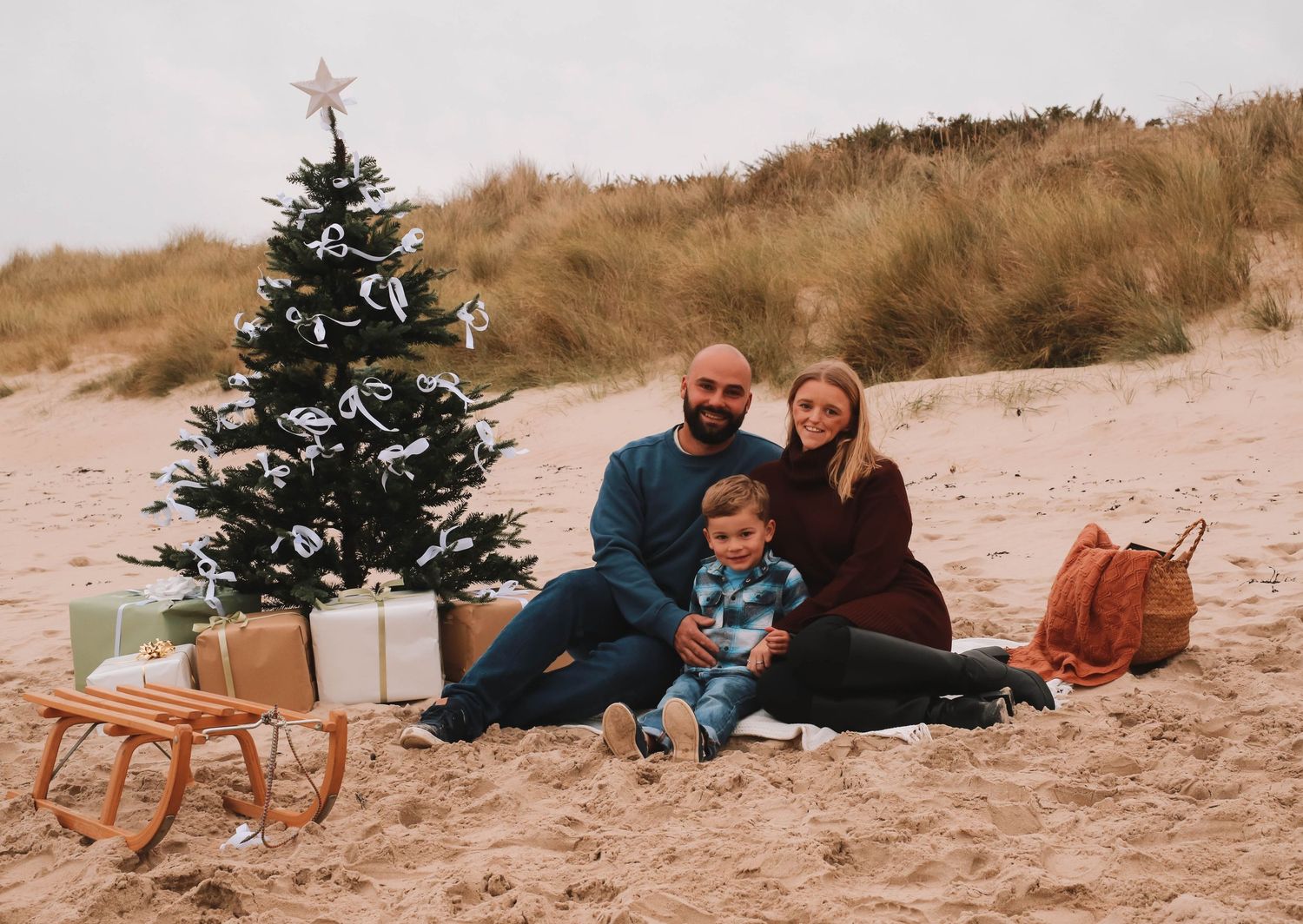 A series of beach holiday photos with Christmas decorations and people sitting on sand near evergreen trees.