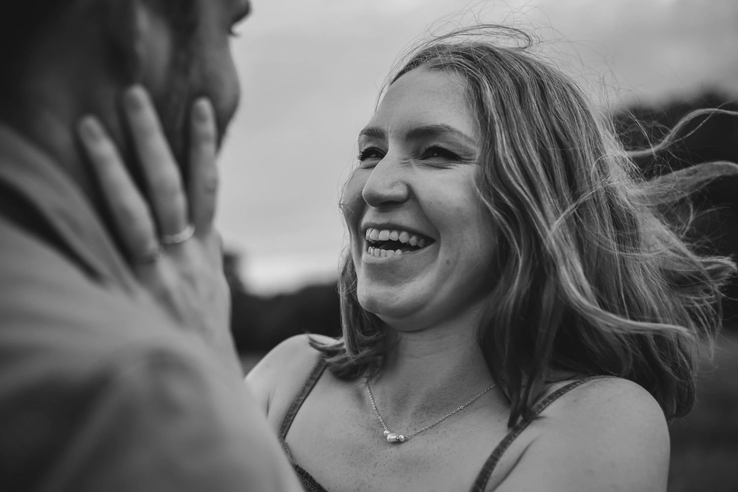 Black and white photo series showing candid moments of joyful laughter and genuine expressions.