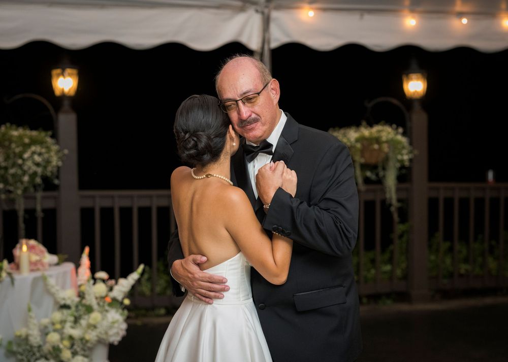 Romantic evening wedding reception scene with string lights and lanterns creating warm ambiance.