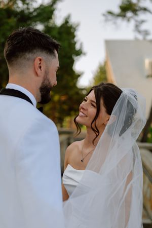 A tender moment between newlyweds sharing an intimate moment during their outdoor wedding ceremony.