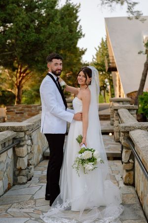 A romantic wedding photo series showing a couple posing on stone steps during golden hour at an outdoor venue.