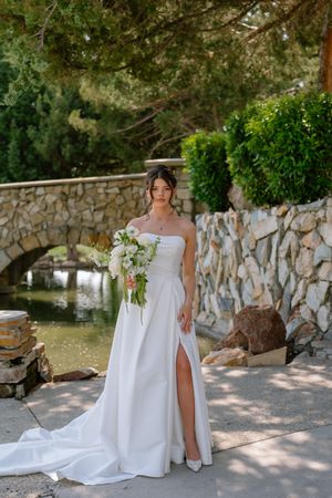A series of bridal portraits taken against a rustic stone wall backdrop in a garden setting.