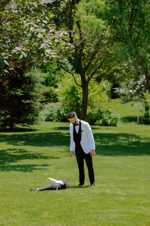 A sequence of playful poses on a green lawn shows two people in formal attire acting out a dramatic scene.