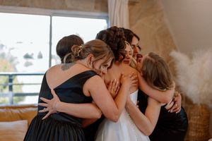 Two people share an intimate embrace while dancing together at a wedding reception.