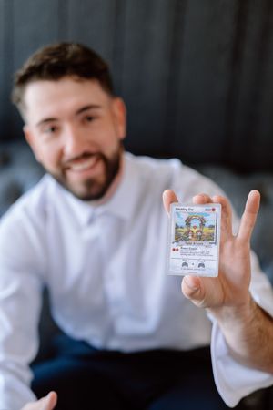 A close-up series showing someone holding and displaying a small card or game cartridge.