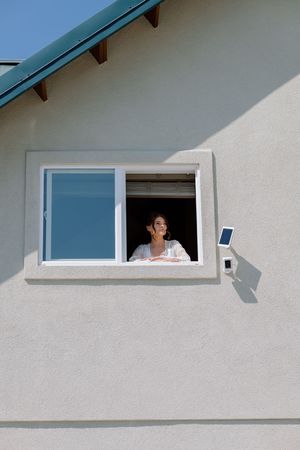 A series of minimalist architectural photos showing a white wall with windows under a blue overhang.