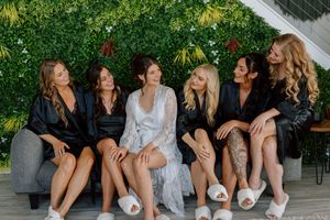 A group sits together on a bench outdoors, sharing laughs and conversation in a garden setting.