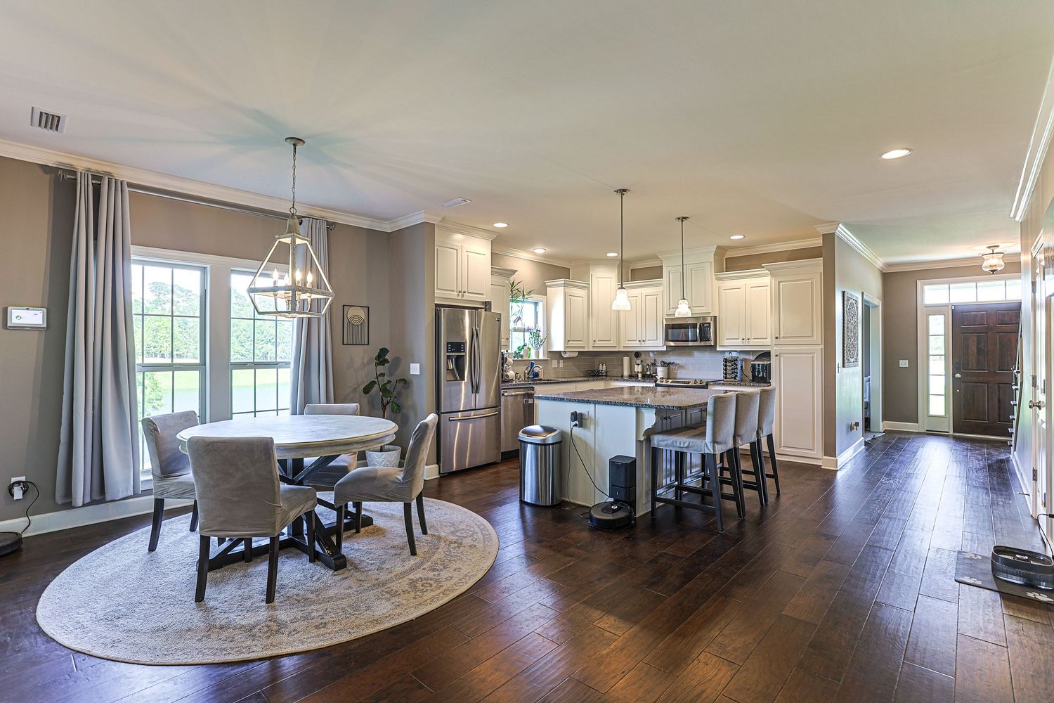 Large covered patio with wood ceiling and ceiling fan offers panoramic views of a lake through floor-to-ceiling windows in Dothan, AL.