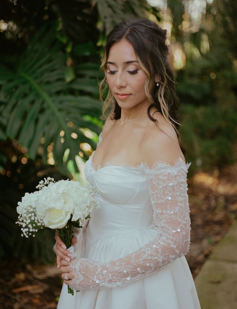 A romantic bridal portrait featuring an ethereal white gown with delicate pearl details and baby's breath bouquet.