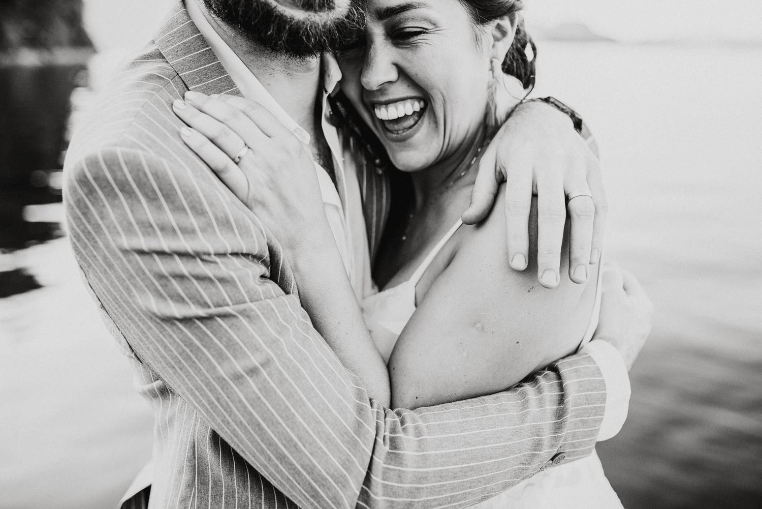 Black and white portrait capturing joyful laughter and genuine emotion between a couple.
