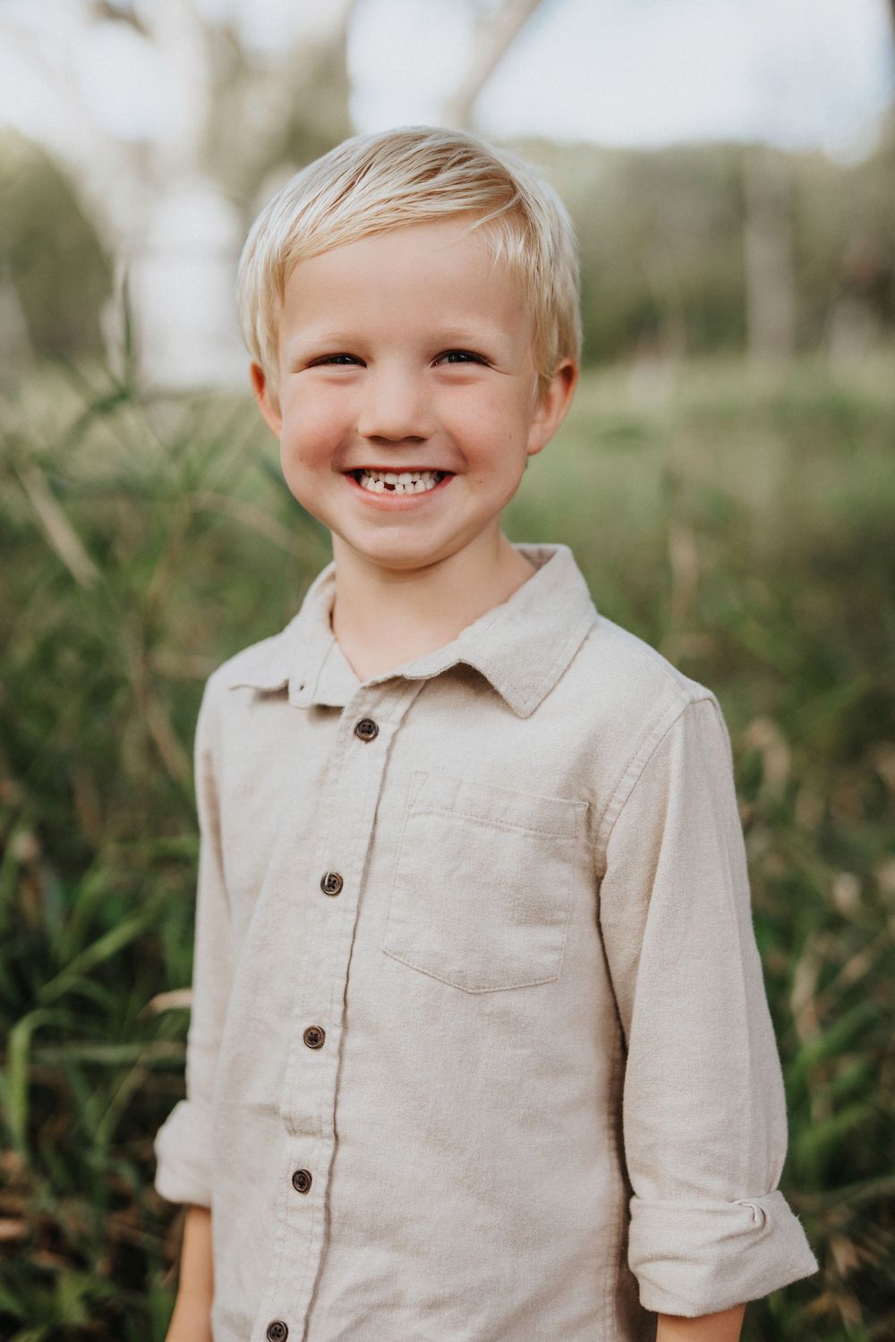 Close-up sequence showing a child wearing a beige linen button-up shirt in an outdoor setting.