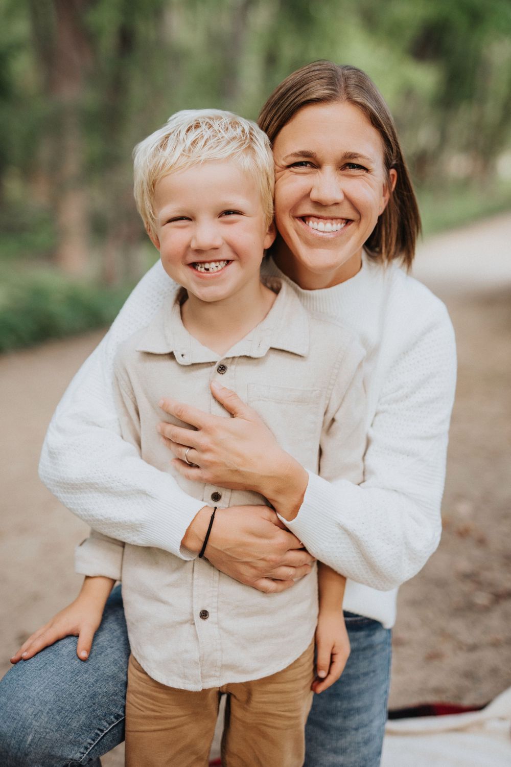 A tender moment of laughter and embraces captured in a series of casual outdoor family portraits in matching white tops.