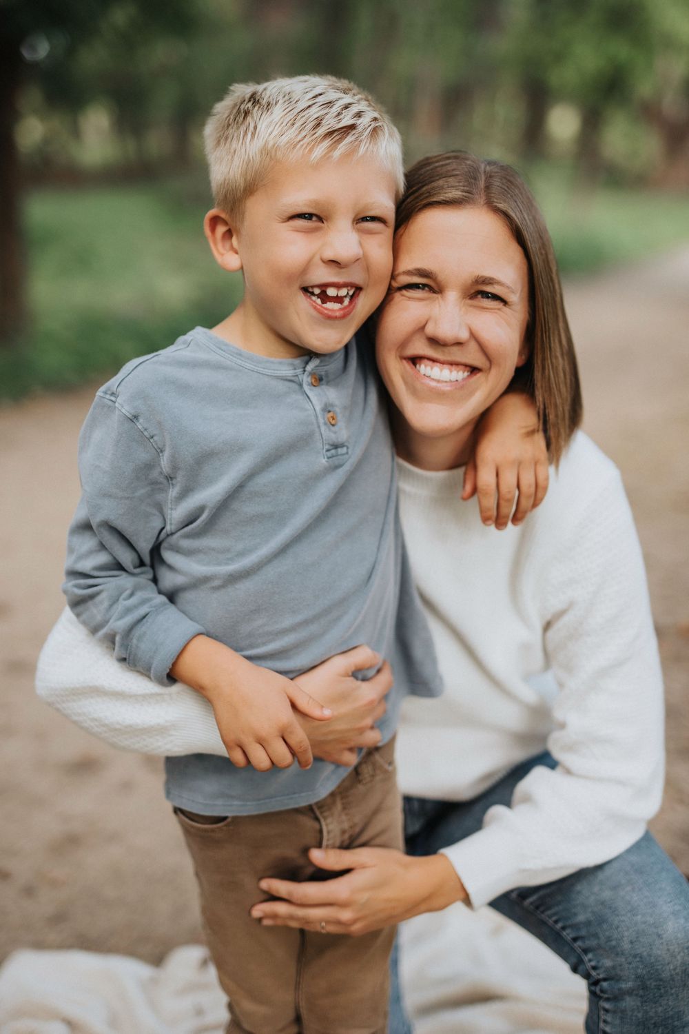 A heartwarming outdoor portrait showing joyful expressions and warm embraces in natural lighting.
