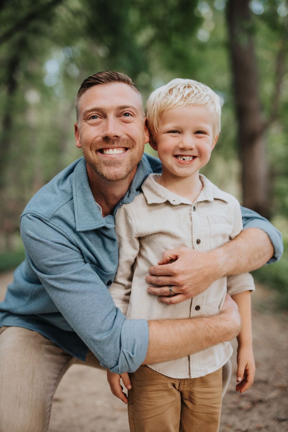 Heartwarming family portraits captured in a sunlit wooded area with natural expressions.