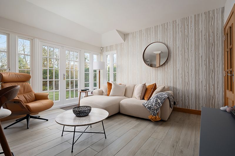 Modern minimalist dining room with white walls, hardwood floors, and panoramic windows showcasing natural light.