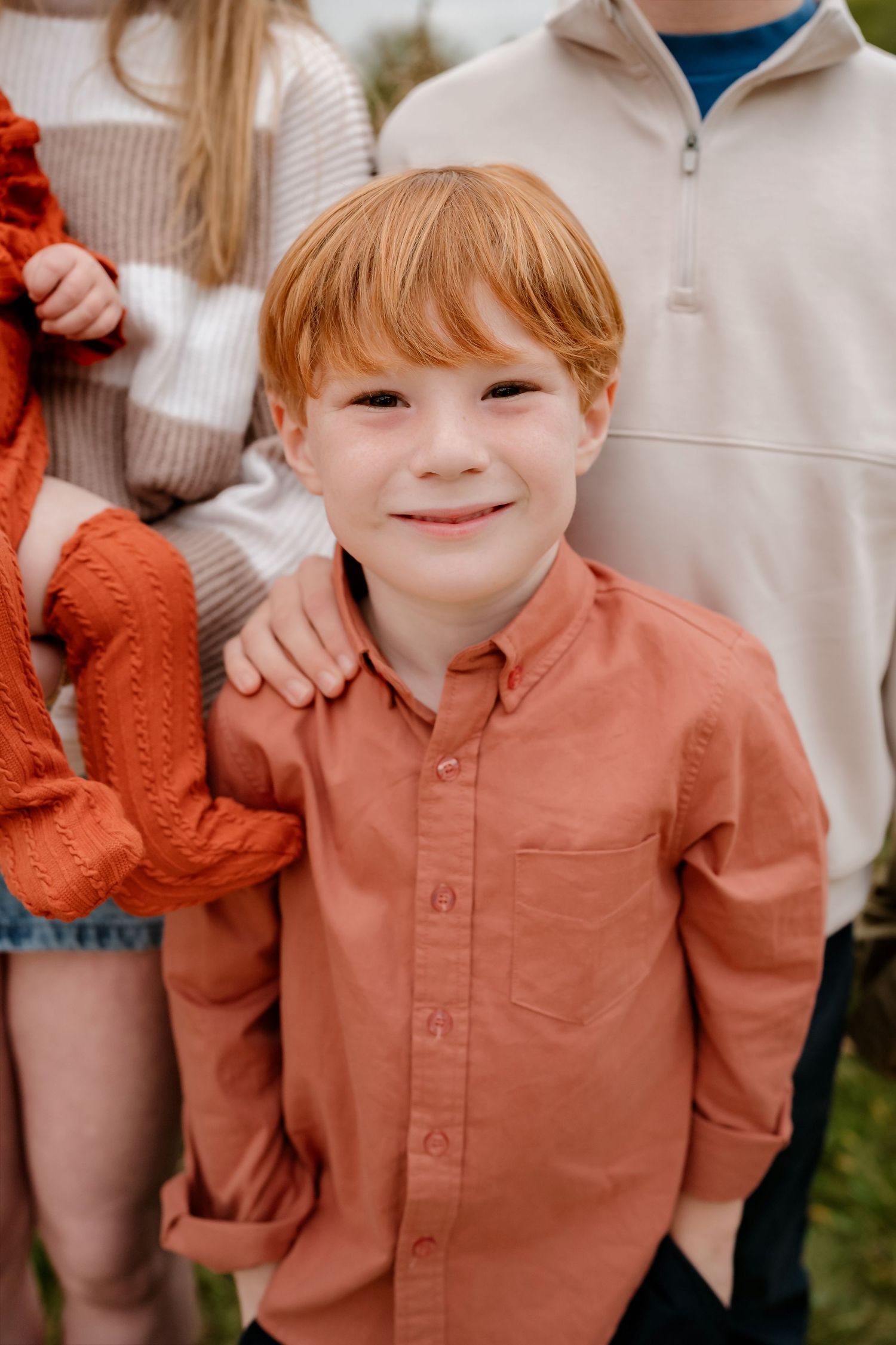 A series of close-up shots showing a child wearing a coral-colored button-up shirt making playful expressions.