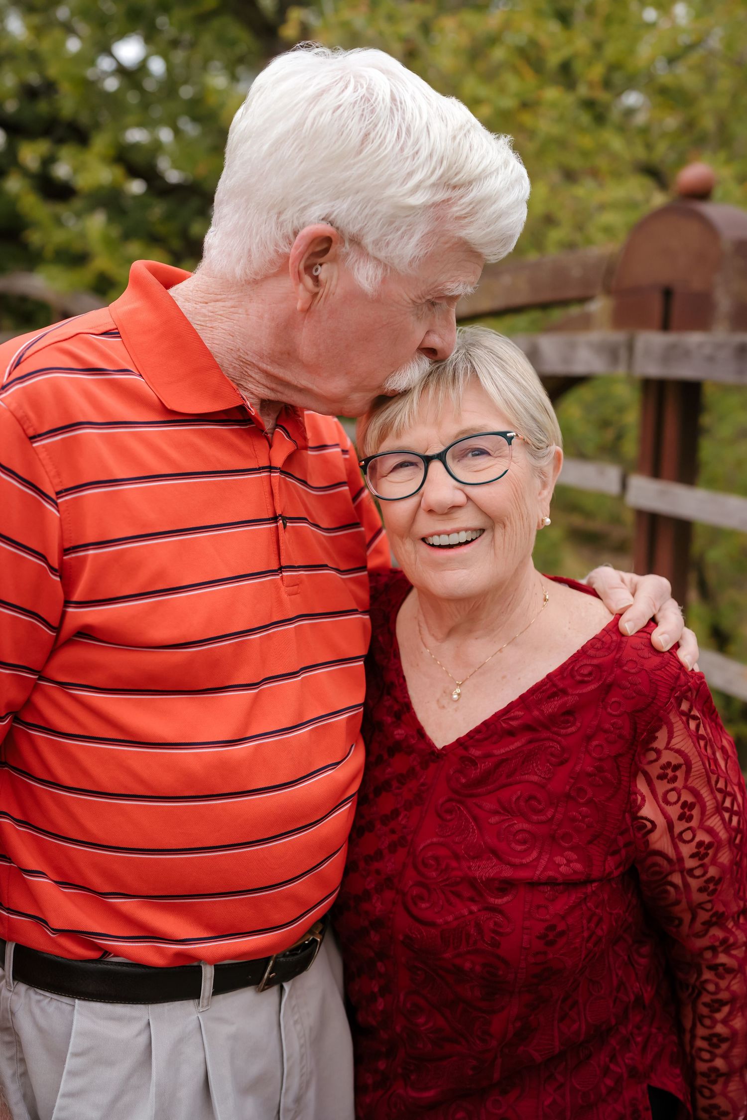 An elderly couple in red and orange striped clothing share tender moments outdoors in a progressive sequence of photos.