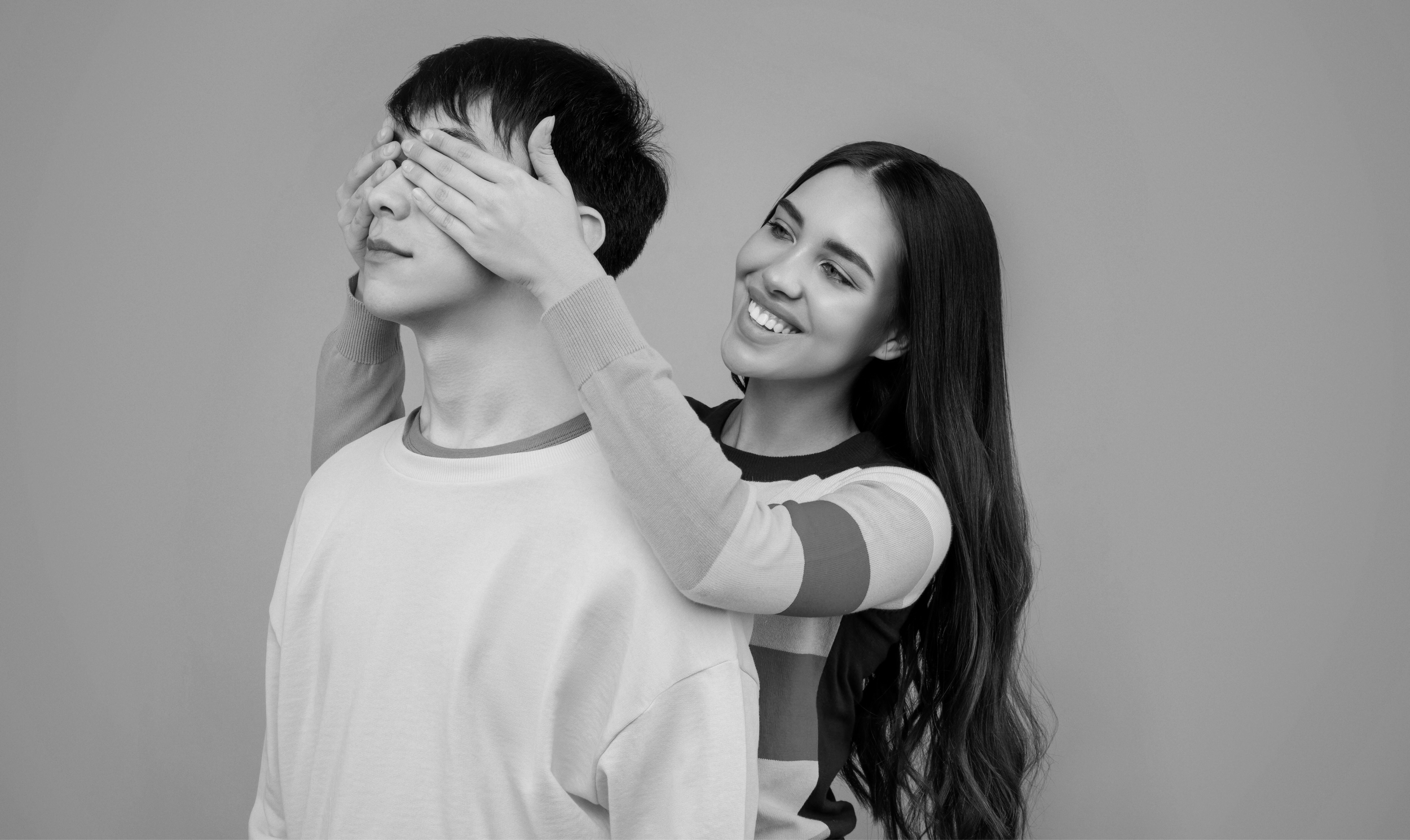 A couple embraces and laughs together in a series of black and white candid romantic photos.