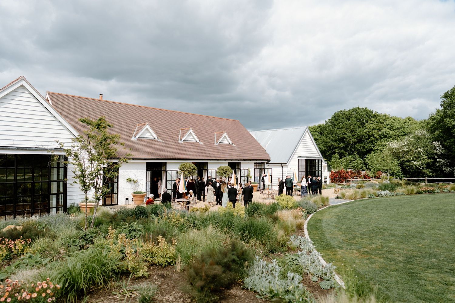 Panoramic view of a coastal wedding venue with white buildings and natural landscaping.