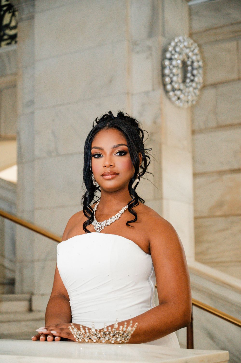 Bridal portrait session on marble steps with ornate architectural details.
