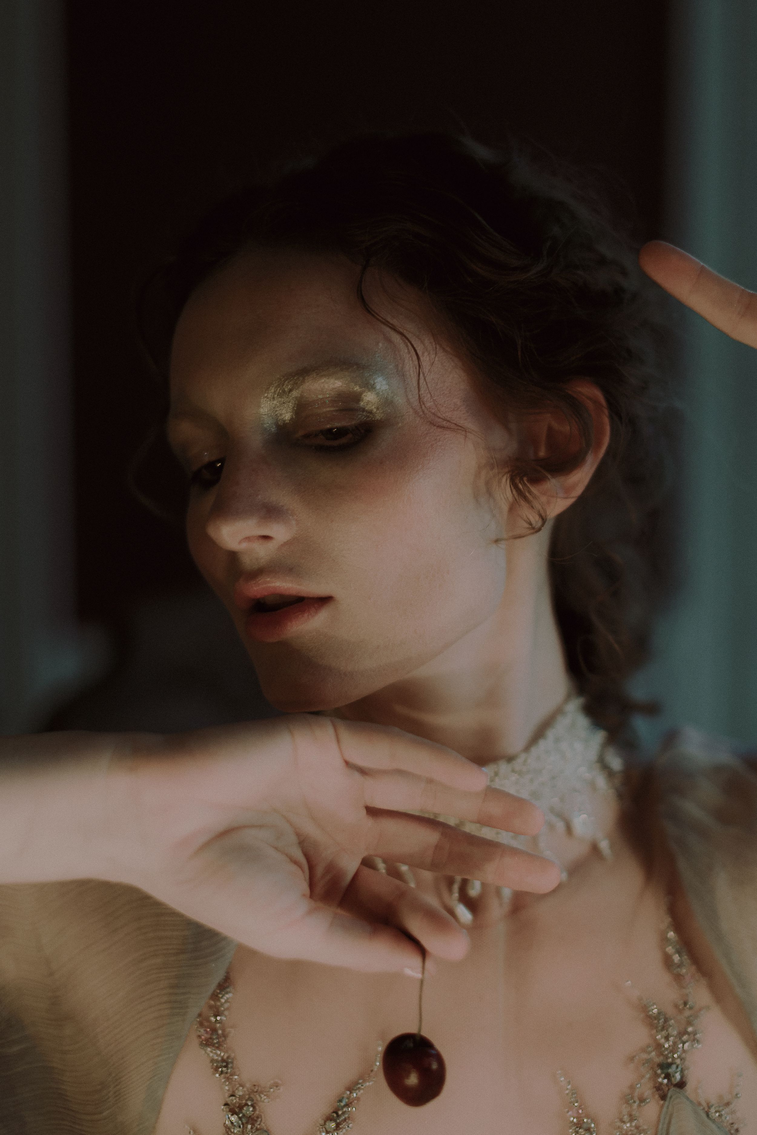 A series of artistic portraits showing delicate jewelry and dramatic lighting against dark moody backgrounds.