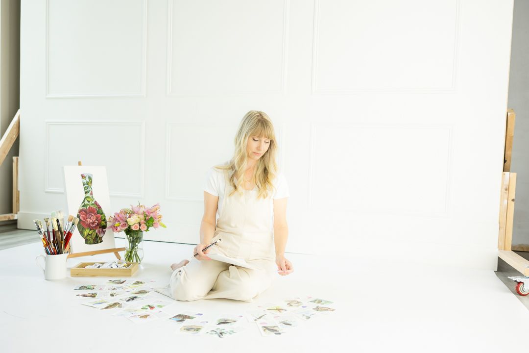A series of four minimalist white photos showing someone sitting on the floor with scattered photos and documents.