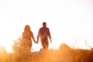 Couple walking in semi-silhouette in golden desert light in Joshua Tree National Park.
