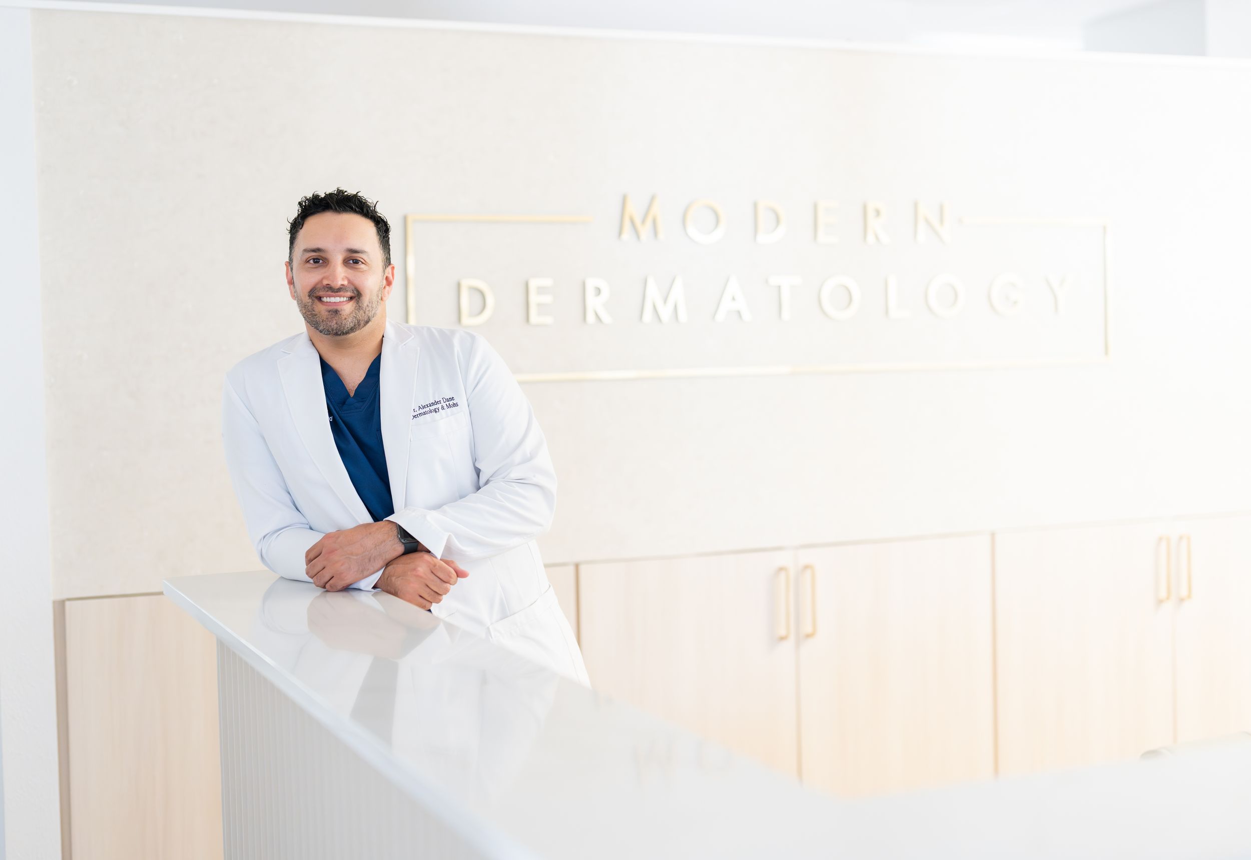 Medical professionals in white coats sit at desks in a modern healthcare office setting.