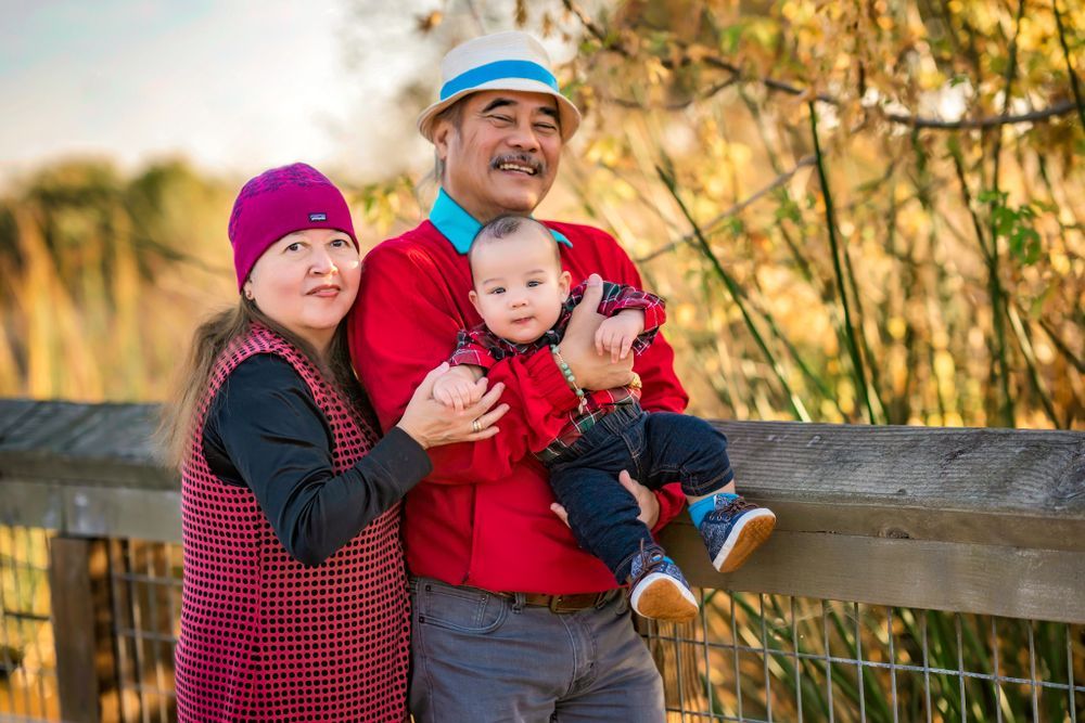 A series of outdoor autumn family portraits at sunset with golden foliage and wooden fence backgrounds.