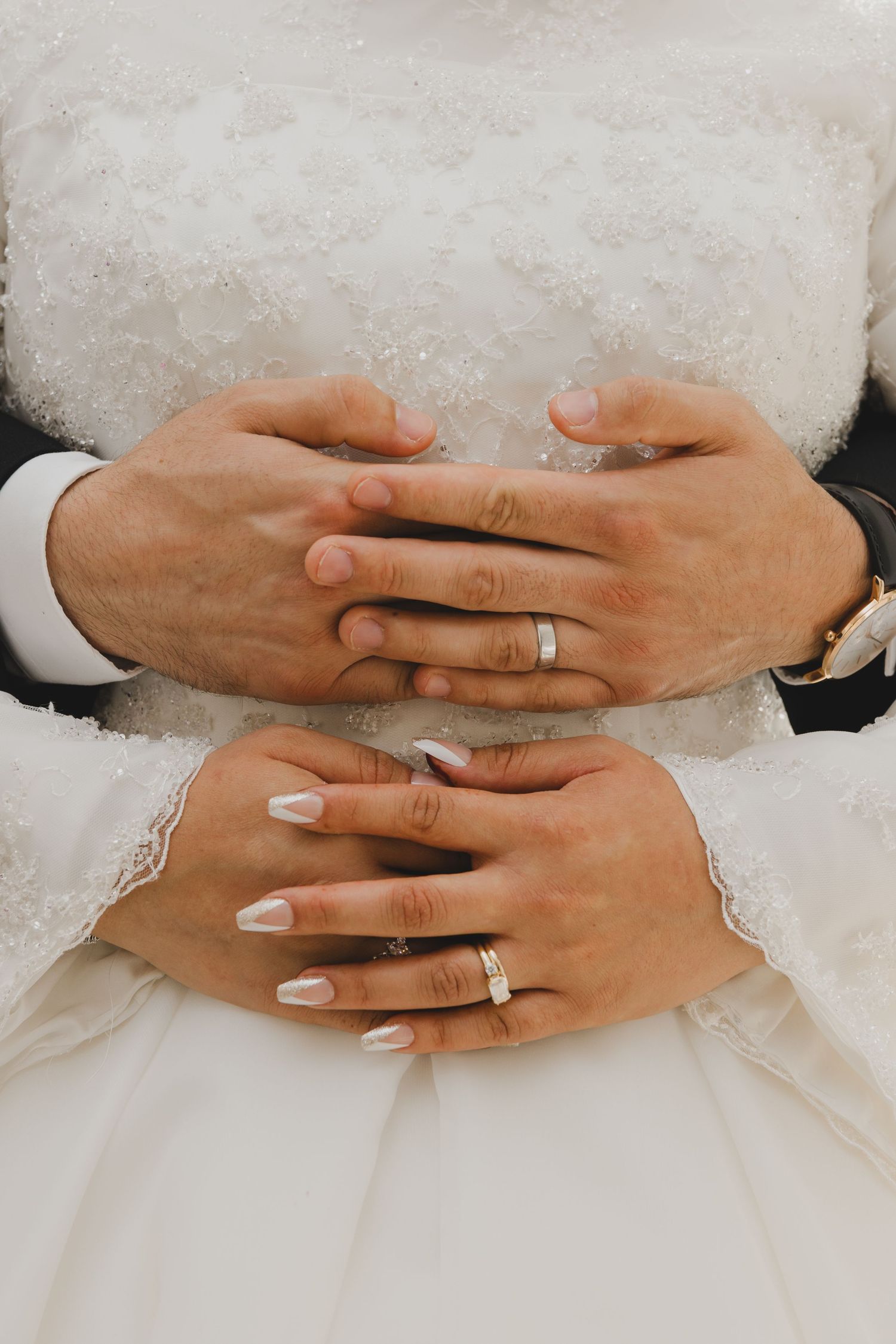 close up photo of bride and groom's hands and their rings