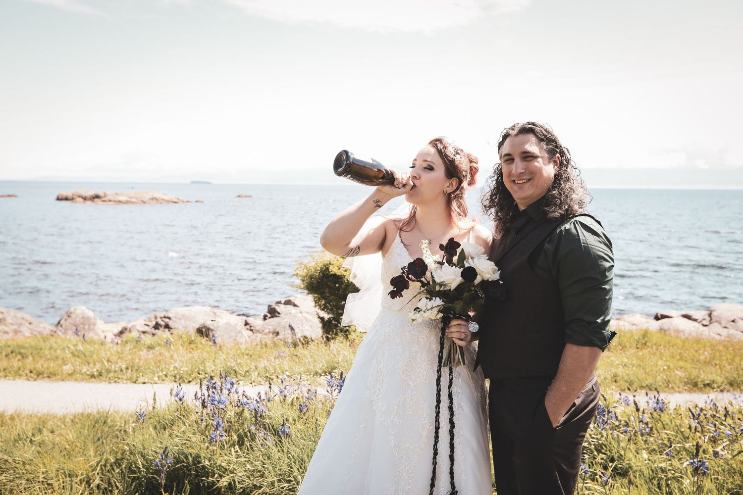 Romantic gothic couple sharing intimate moment with fall bouquet of white and orange flowers.