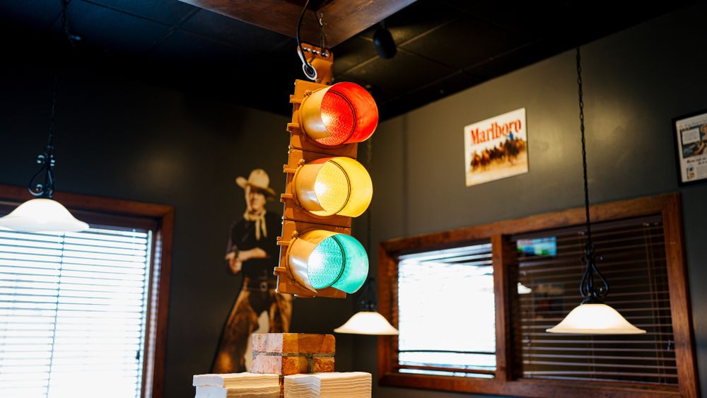 Decorative traffic light fixture with red, yellow and green bulbs mounted indoors.