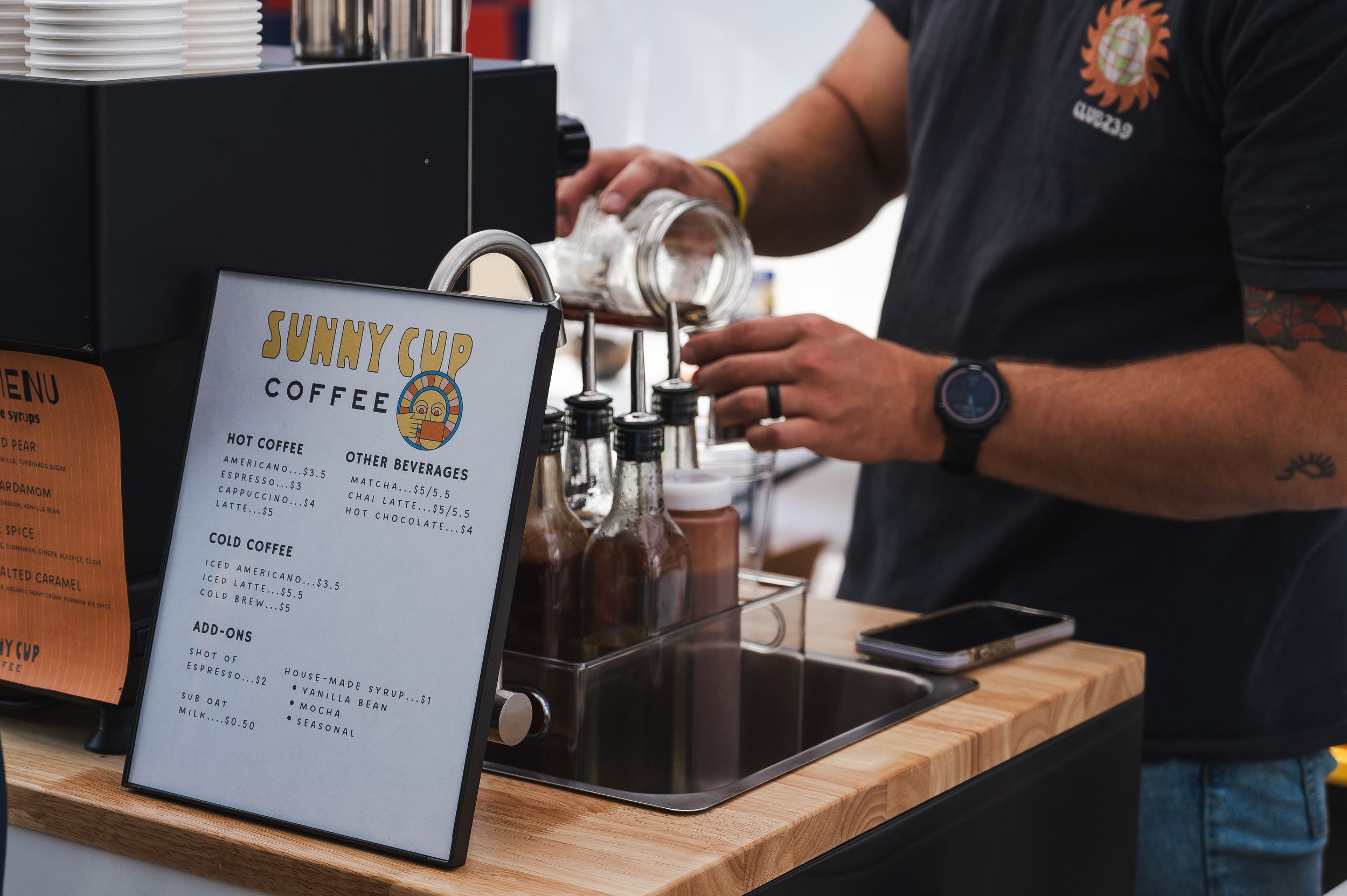 Coffee shop menu and espresso machine setup on wooden counter.