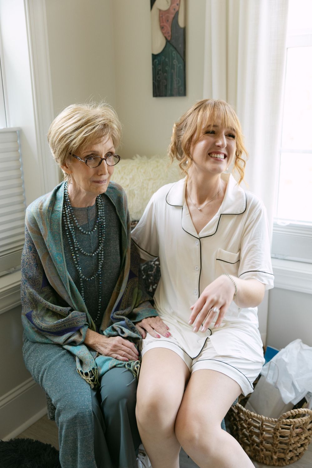 Two people sharing a candid moment while sitting by a window.