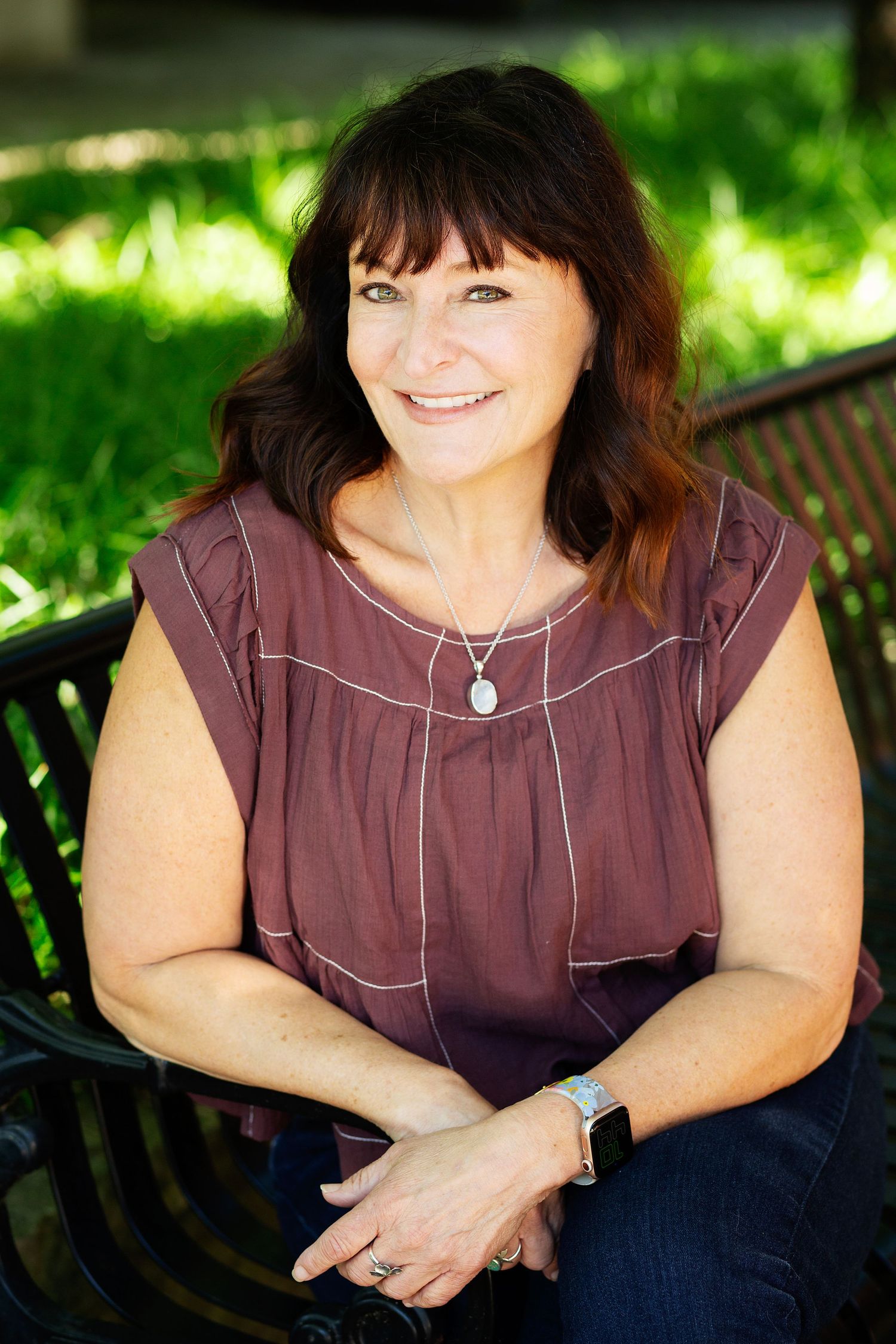 lifestyle headshot of woman smiling sitting on a bench in anchorage ky