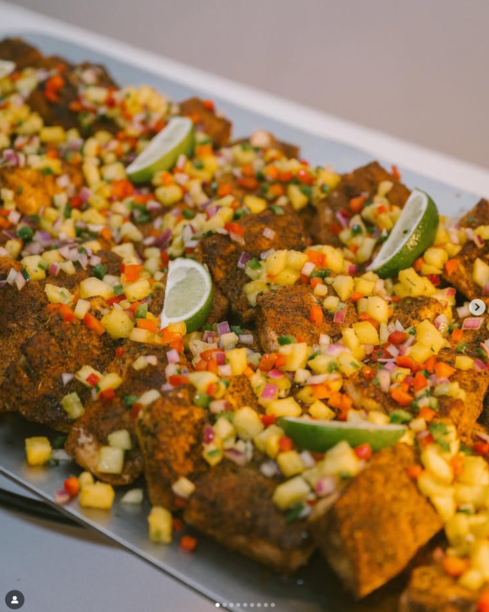 Close-up sequence showing crispy chicken topped with colorful corn salsa and lime wedges on a long white serving platter.