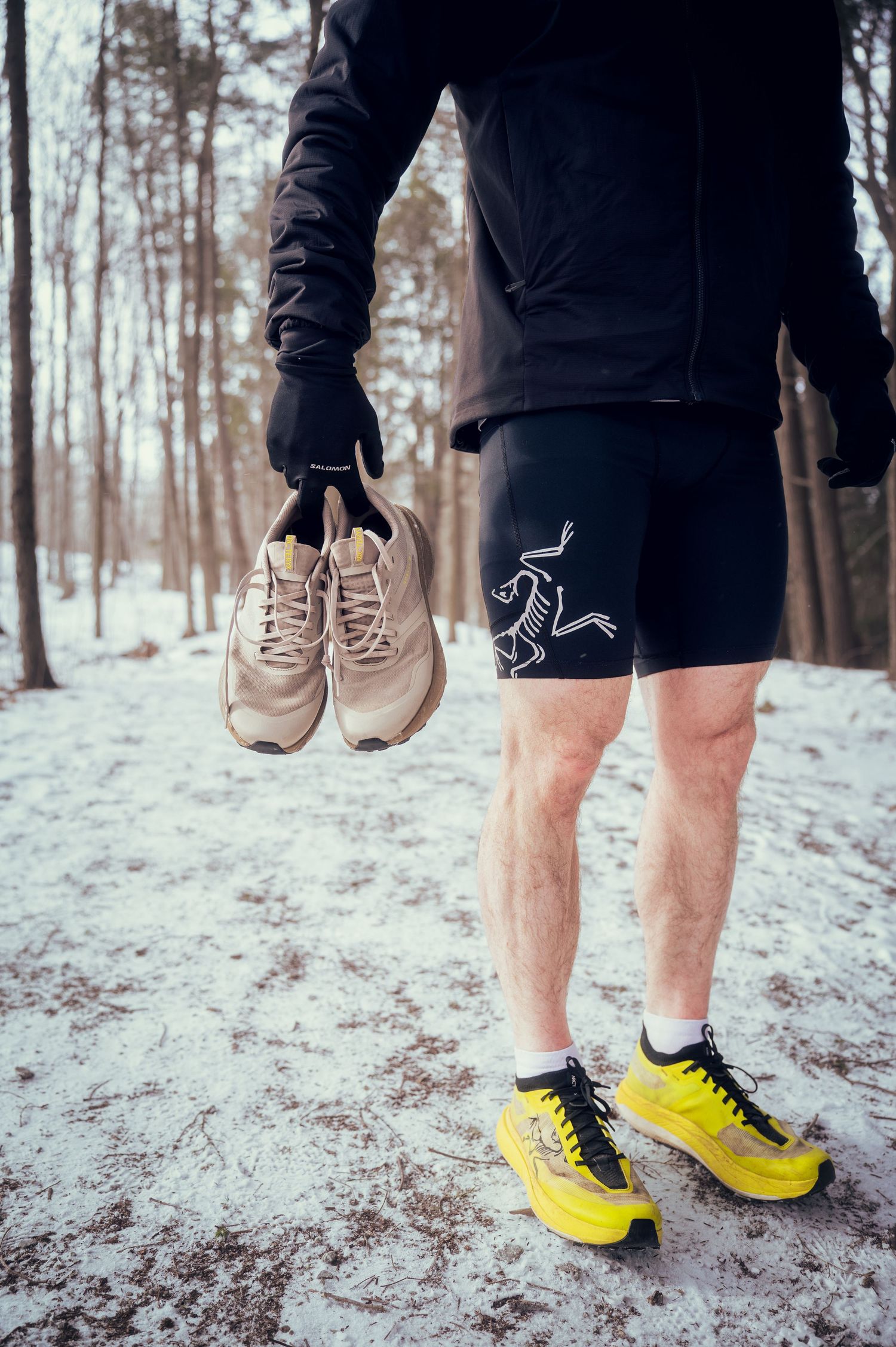 A series of views showing a person's legs in black shorts wearing yellow sneakers and beige shoes in snowy winter forest.