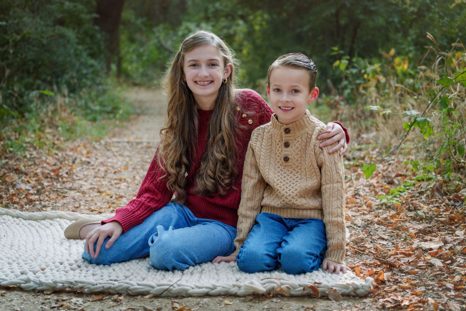 family photo session fall season leaves Colleyville nature center TX siblings sitting on a blanket smiling pose candid