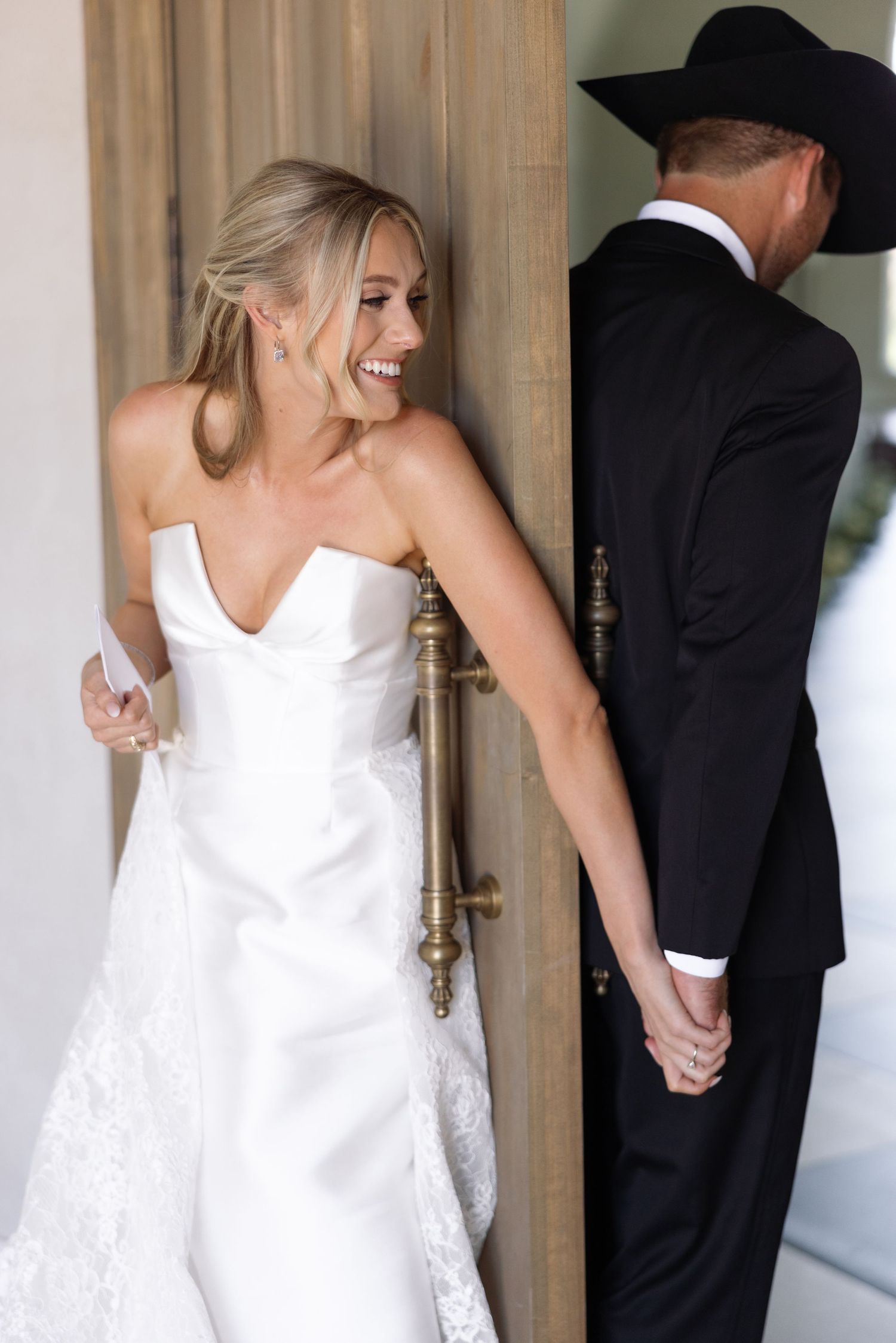 Four progressive shots of a bride in a white dress standing next to someone in black near white columns.