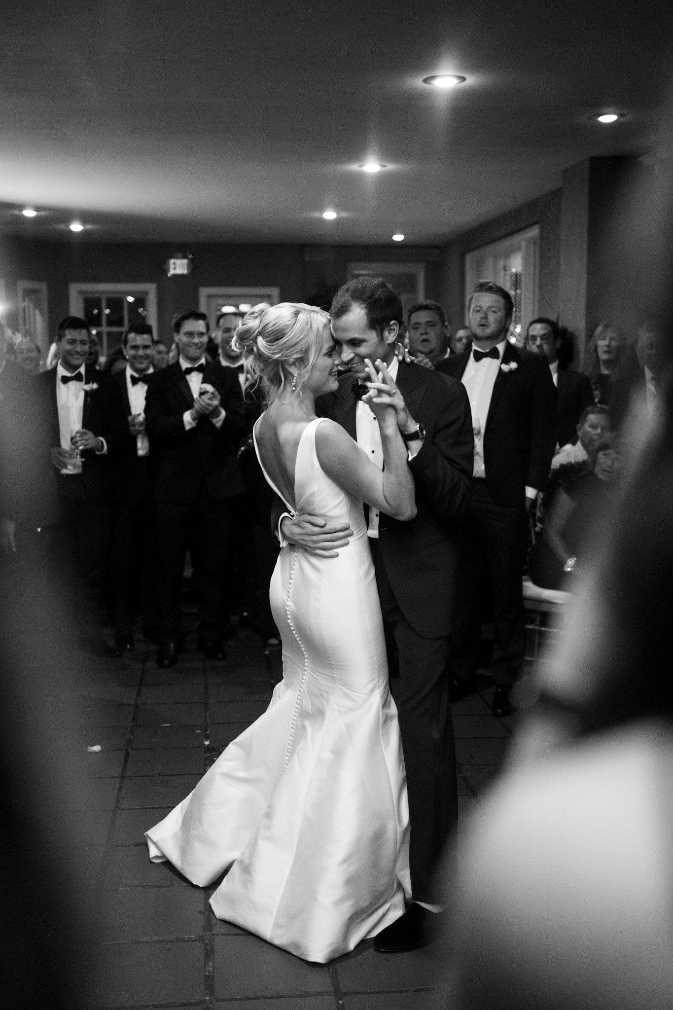 Black and white reception photos showing a couple dancing surrounded by guests.