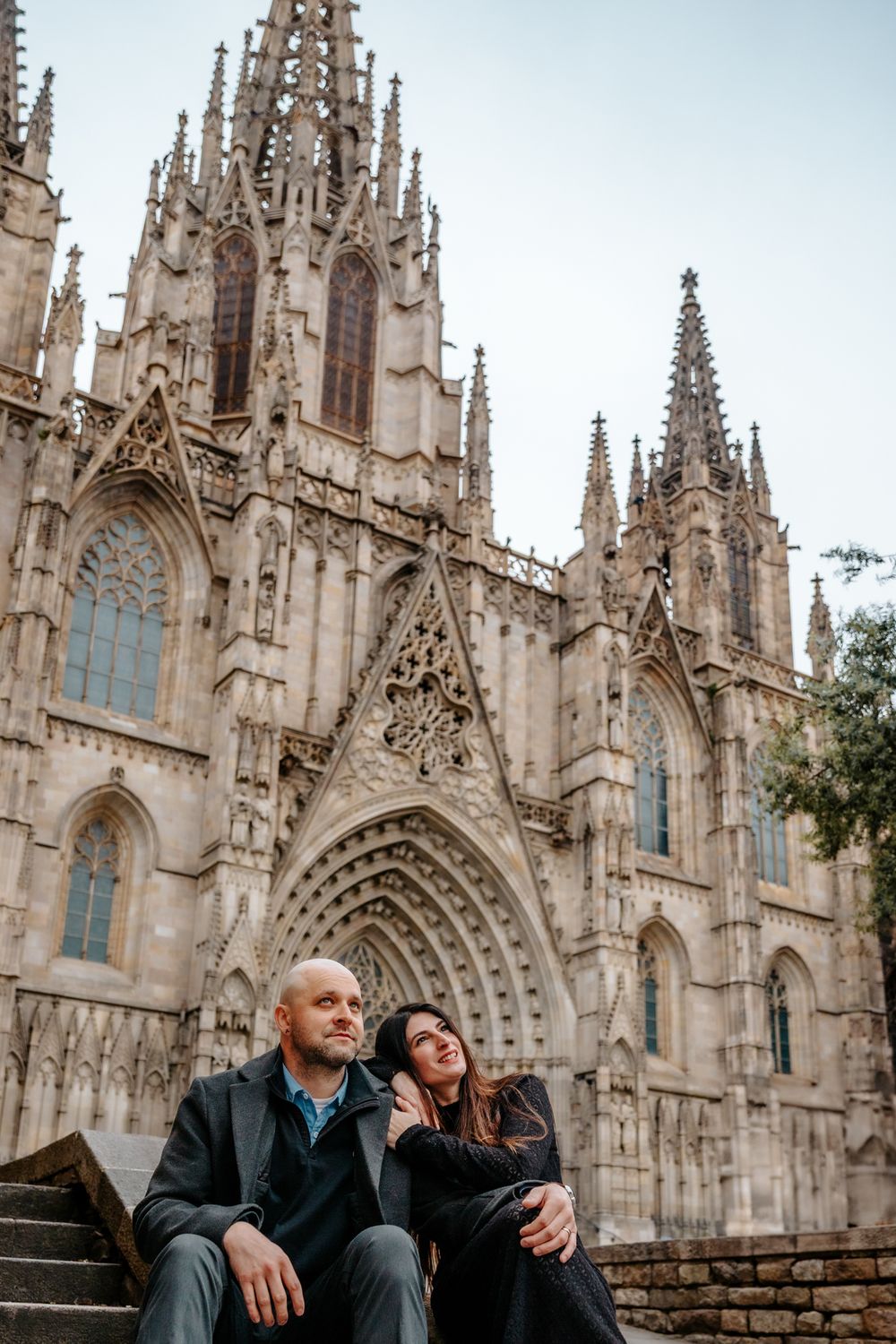 Wide shot of the couple walking past Gothic columns hand in hand
