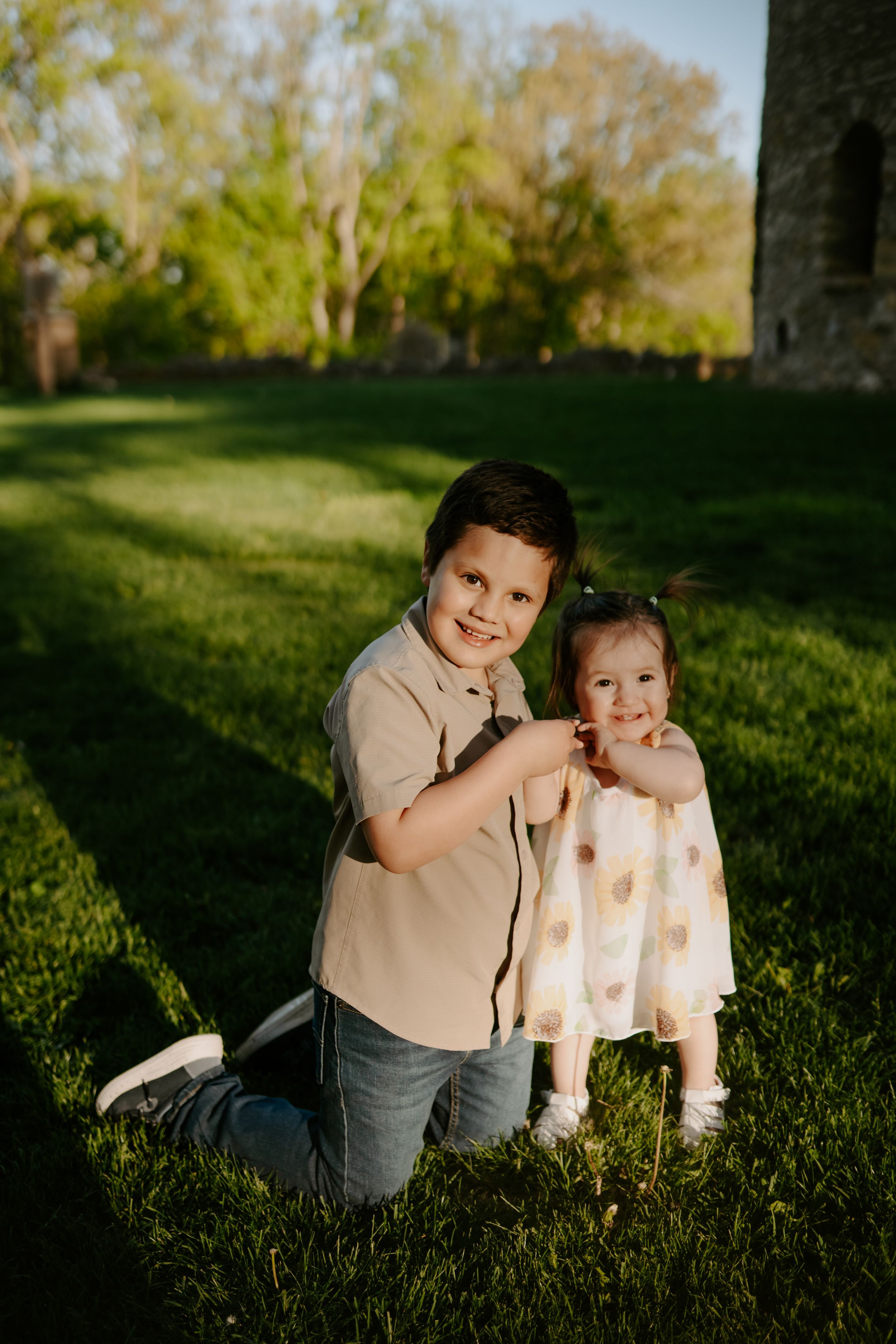 Children laying on grass during golden hour photo session.