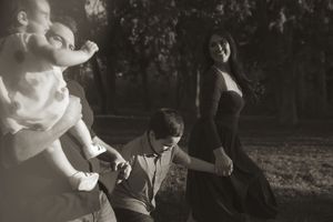 Black and white artistic portrait series of joyful family moments outdoors.