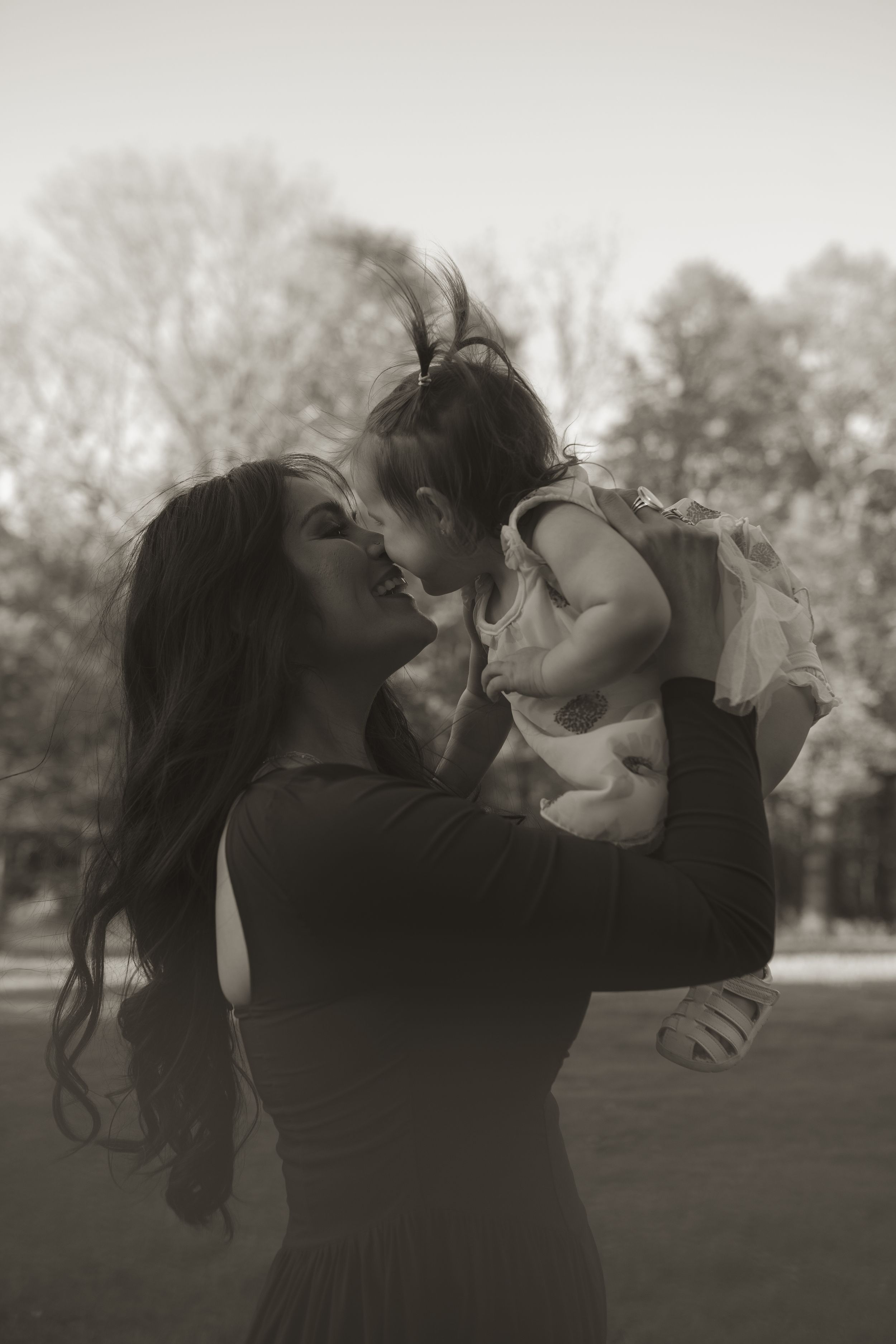 Intimate family moment captured in black and white photography outdoors.