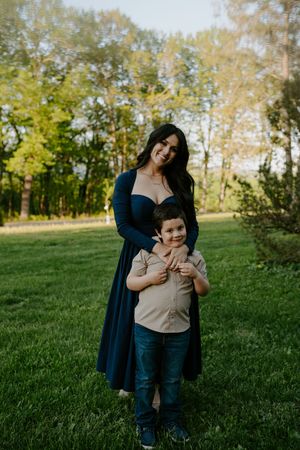 Candid family portraits captured in a lush green outdoor setting.