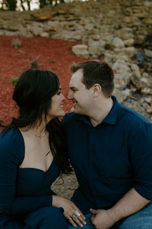 An intimate couple's portrait session with a weathered stone wall background at dusk.