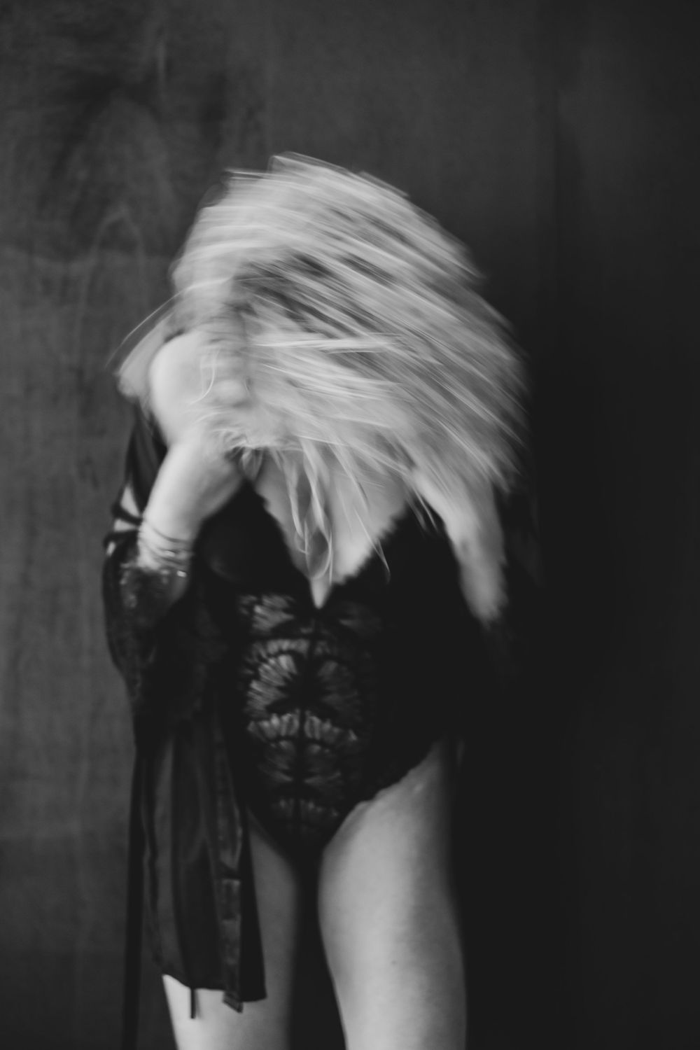 A black and white artistic portrait series showing progressive motion blur of a person's head against a dark background.