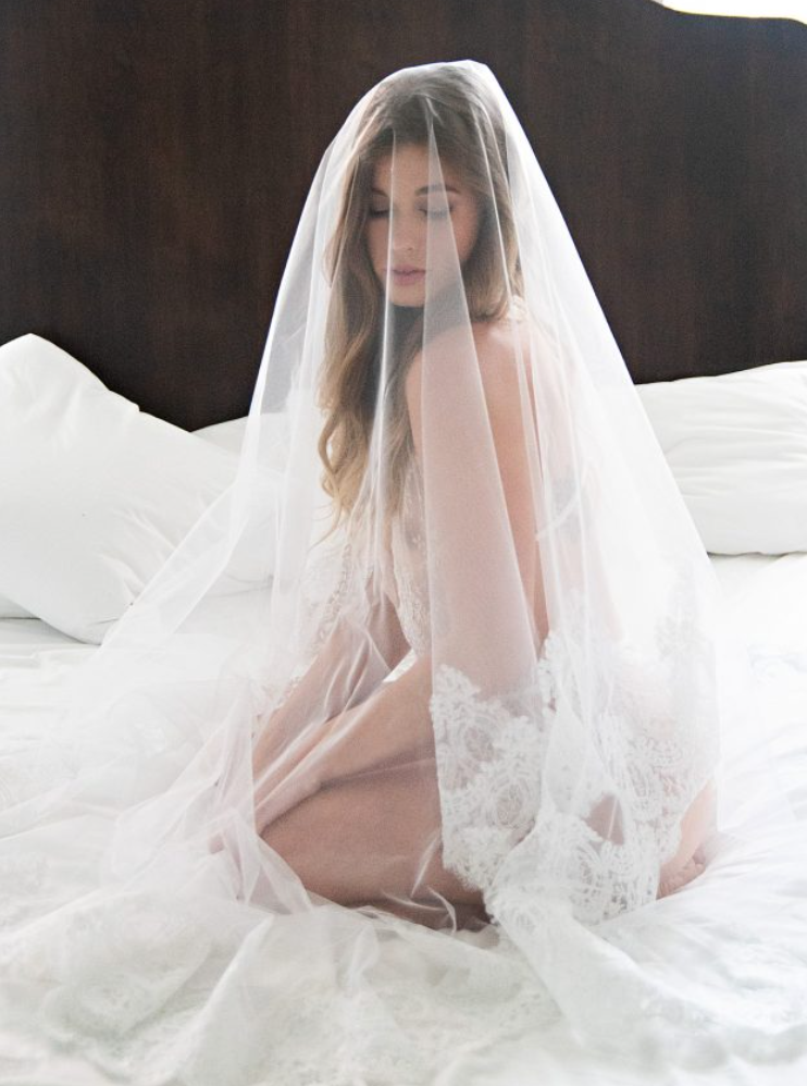 Ethereal artistic photo series showing figure draped in flowing white sheer veil fabric against light background.