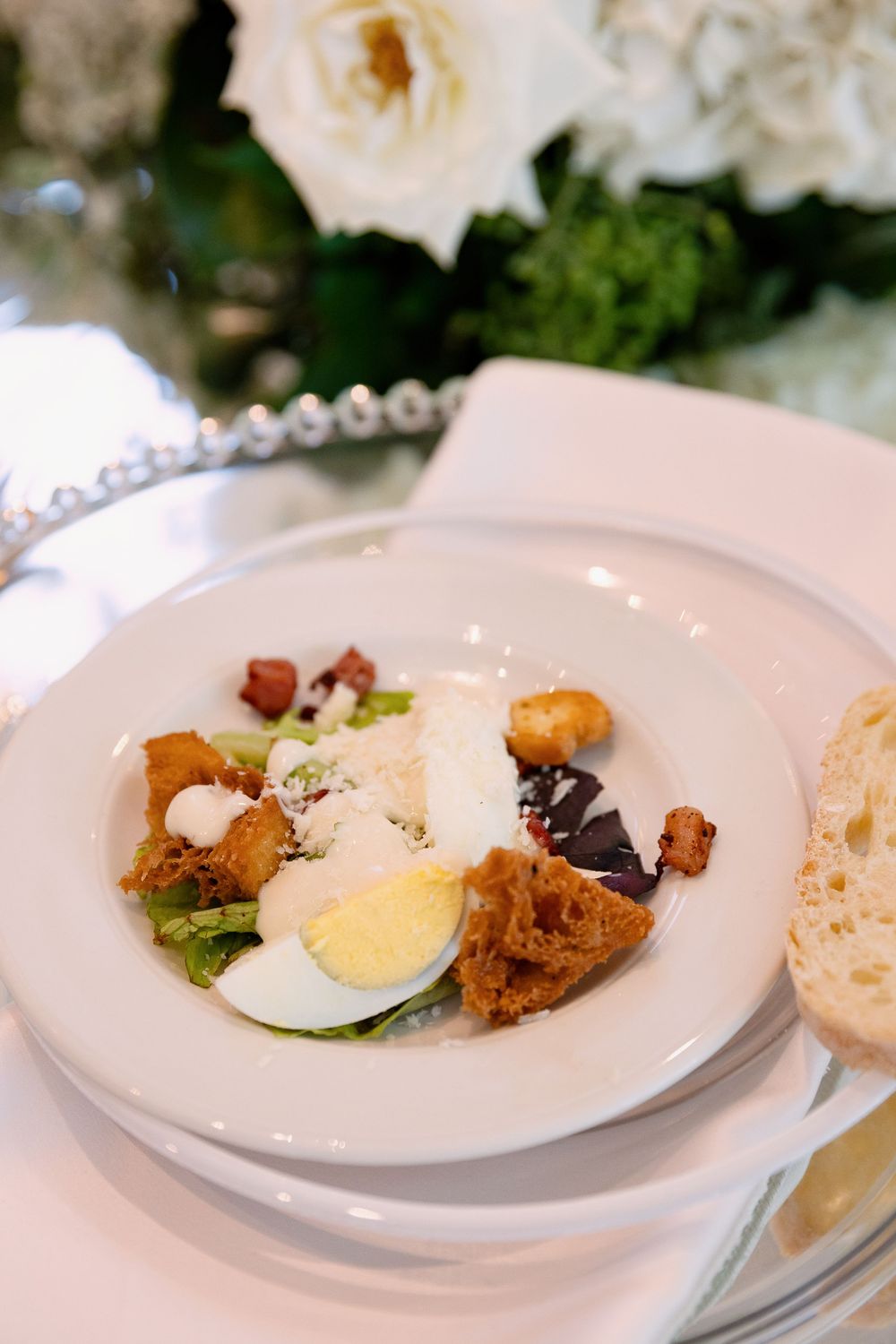 Five elegant white plates showcasing a fine dining presentation with boiled eggs and delicate garnishes.