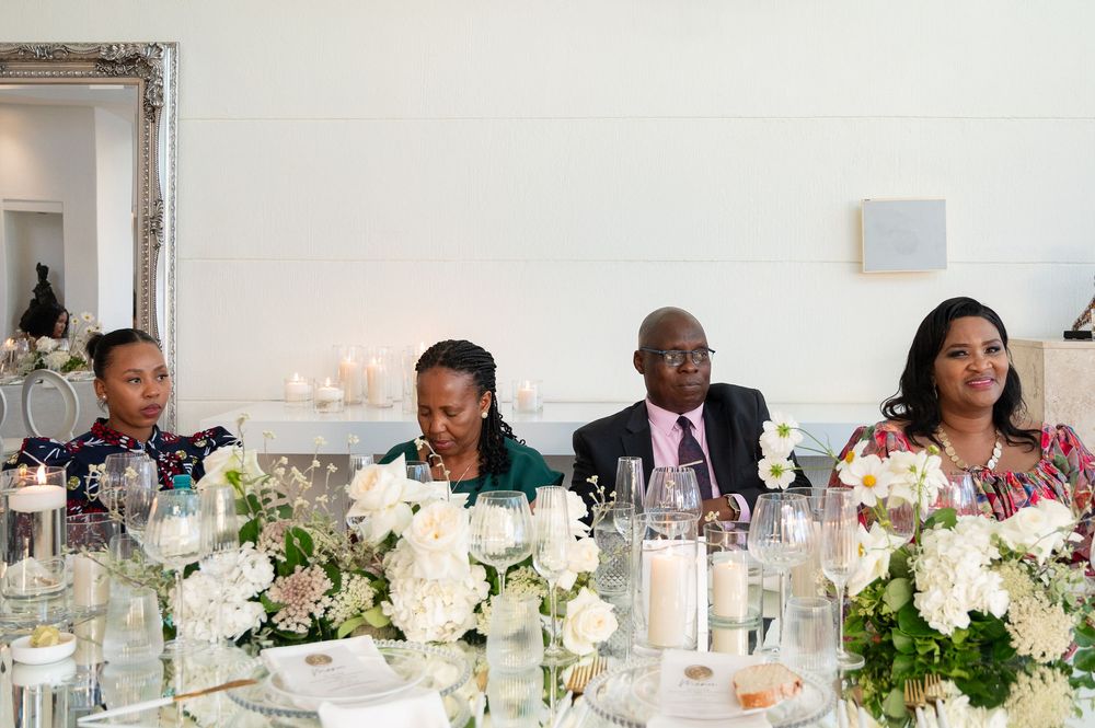 Reception table decorated with white floral arrangements and candlelight during an elegant wedding celebration.
